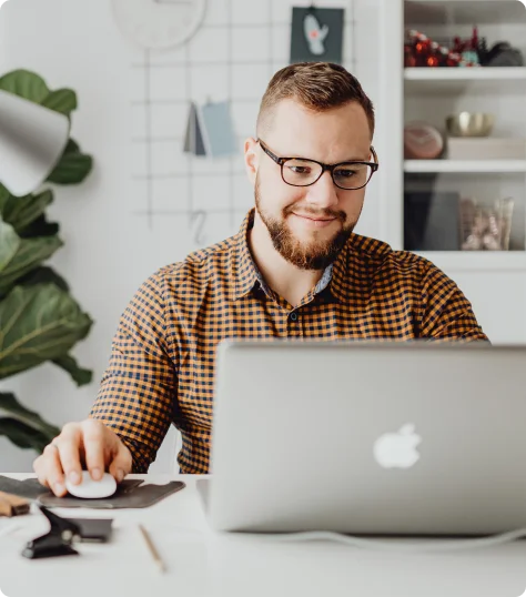 A man is working on macbook with the help of mouse